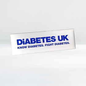 Diabetes UK white lapel badge with butterfly clasp, shown on a plain background, approx. 4.5cm x 1.5cm in size