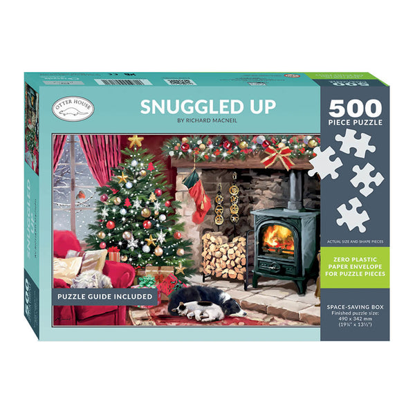 A 500-piece jigsaw puzzle box titled 'Snuggled Up' by Richard Macneil. The packaging features a festive Christmas scene with a decorated tree, a cozy fireplace, and a sleeping dog, set against a teal and dark gray background with white puzzle piece graphics.