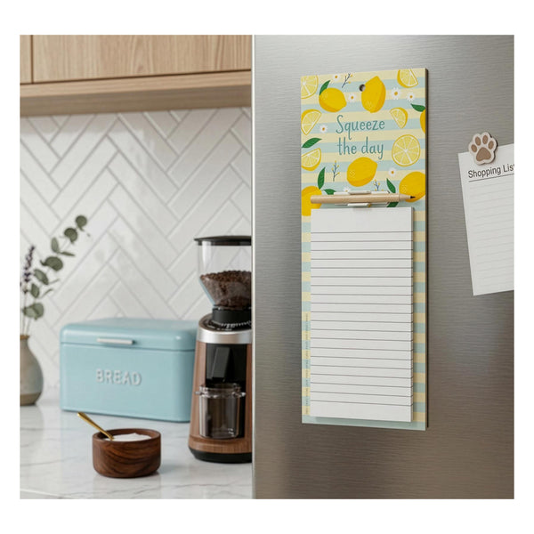 Image of a jotter on a fridge with a design featuring lemons and a pencil. Blue bread bin and coffee maker in the background.