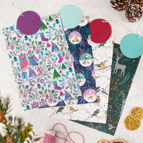 Set of Christmas-themed wrapping paper sheets with festive designs on a white surface.