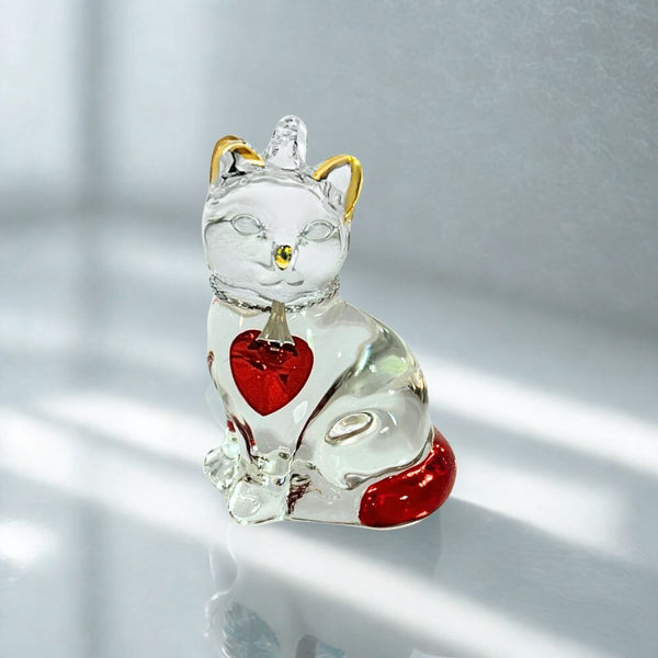 Glass cat with red and gold colour on a white background.
