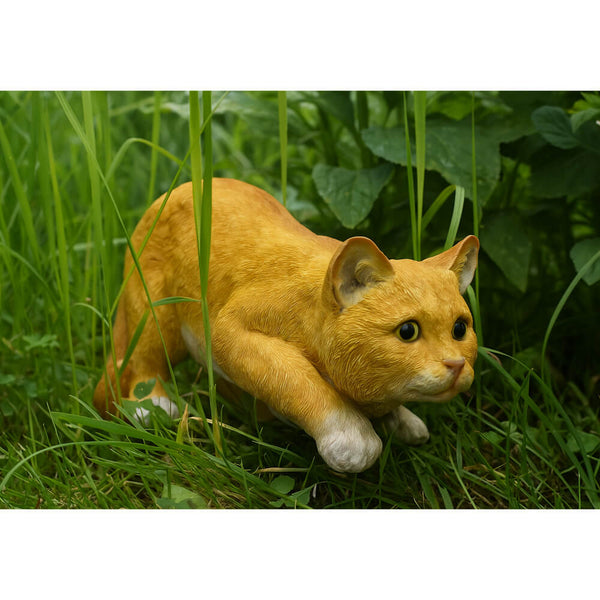 Ginger cat ornament in long grass on a white background.