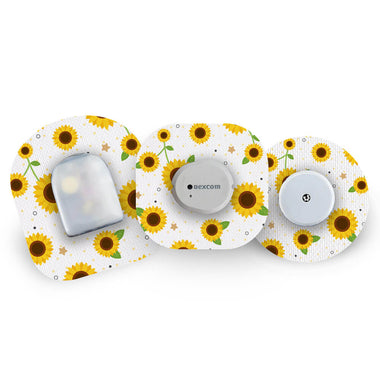 Three glucose monitoring sensors with sunflower pattern CGM patches on a white background