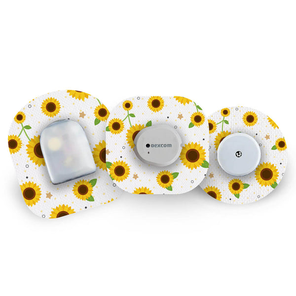 Three glucose monitoring sensors with sunflower pattern CGM patches on a white background