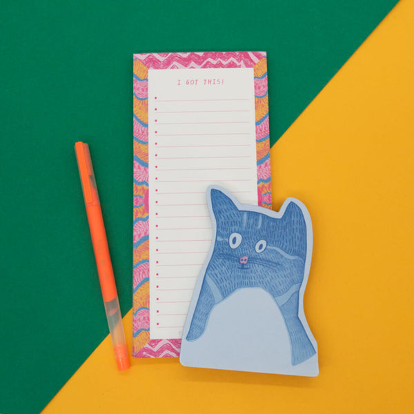 Notepad with cat design and colorful border on a green and orange background