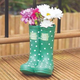 Green welly-shaped resin planter with colourful polka dots and ‘Love Grows Here’ slogan.