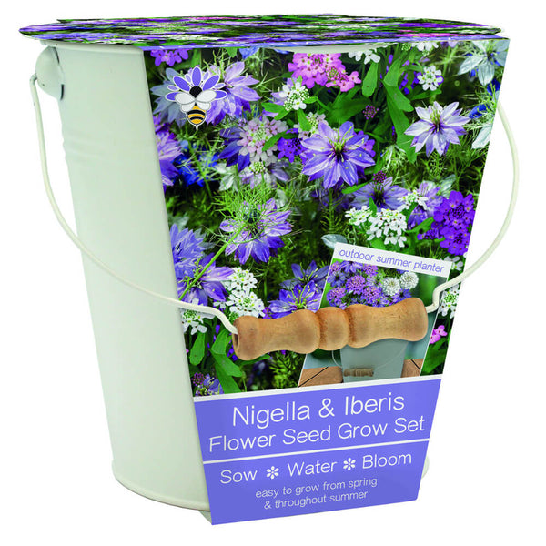 Nigella & Iberis Flower Seed Grow Set in a white metal bucket with a handle, featuring a floral label with purple flowers and a wooden-handled tool.