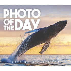 Square cover for a 2027 desk calendar featuring a large whale breaching ocean water at sunset, with the text 'PHOTO OF THE DAY' and '2027 DESK CALENDAR' on the cover.