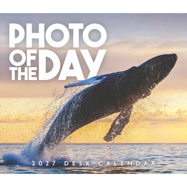 Square cover for a 2027 desk calendar featuring a large whale breaching ocean water at sunset, with the text 'PHOTO OF THE DAY' and '2027 DESK CALENDAR' on the cover.