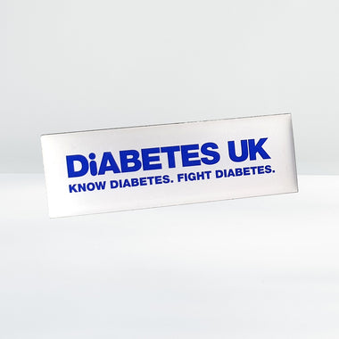 Diabetes UK white lapel badge with butterfly clasp, shown on a plain background, approx. 4.5cm x 1.5cm in size